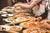 Group of people constructing pizzas